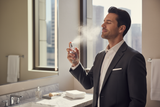 Hombre rocíandose perfume